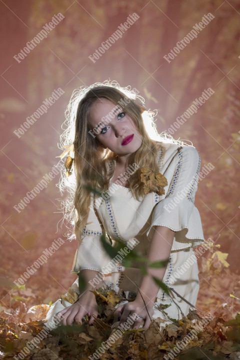 Beautiful young woman in white dress enjoying autumn park.