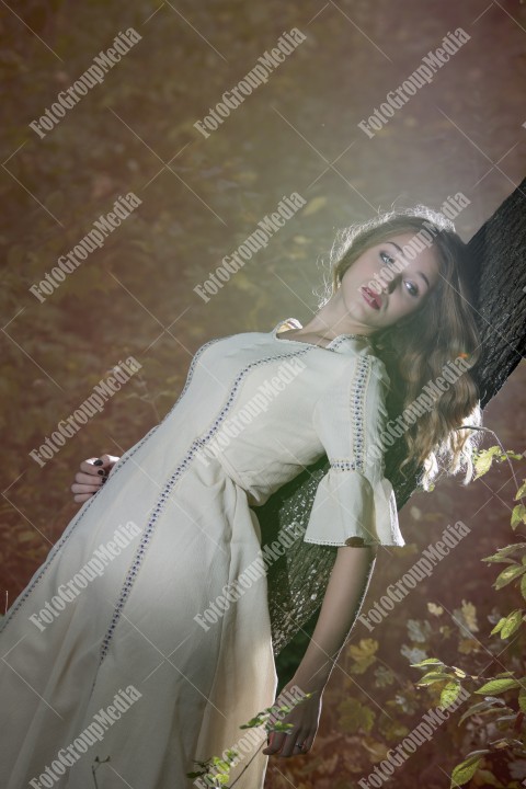 Romantic portrait of a girl laying on a tree.