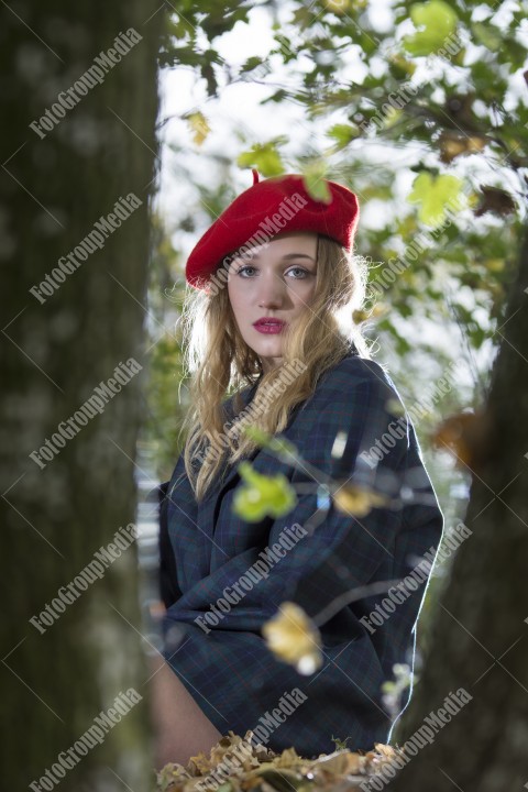 Young woman posing for camera dressed in red berette and big jacket