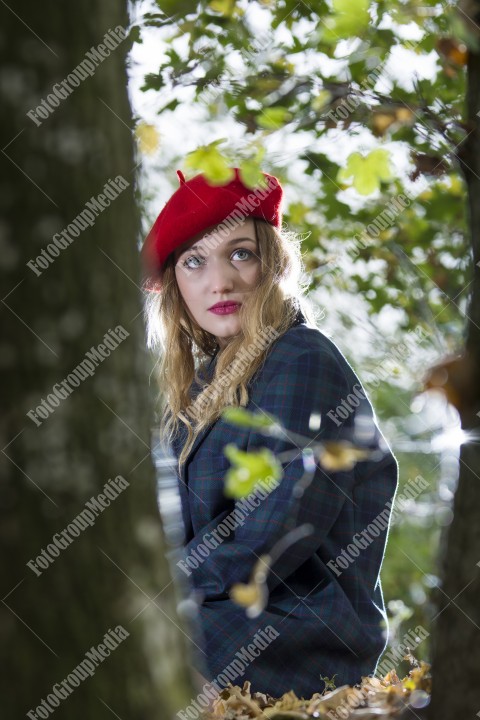 Blonde young woman dressed in oversized jacket and red berette