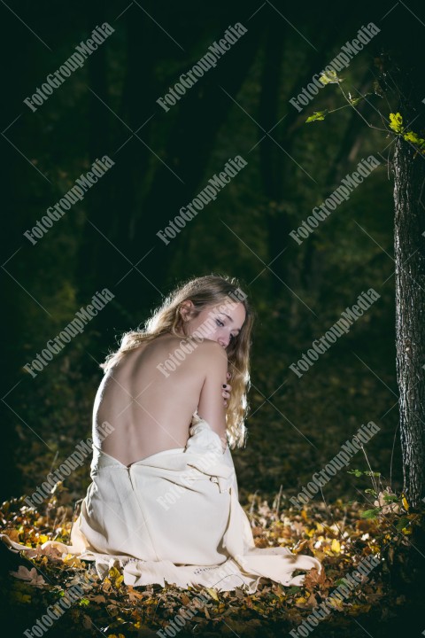 Shy woman covering herself with white dress