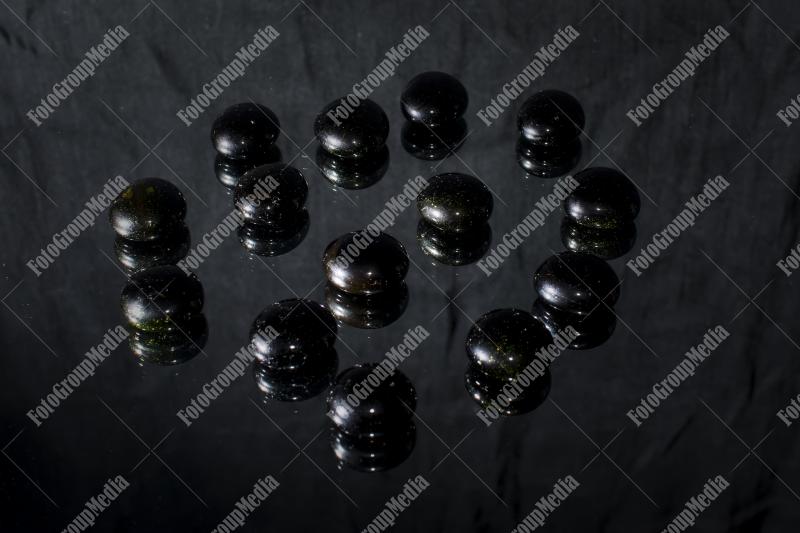Black pebbles isolated on black background