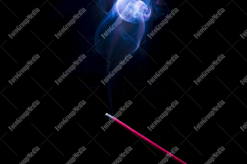 Blue smoke incense stick on black background