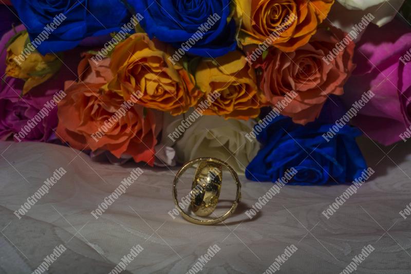 Wedding rings and blue, yellow roses