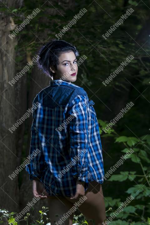 Pretty young girl in plaid shirt posing outdoor
