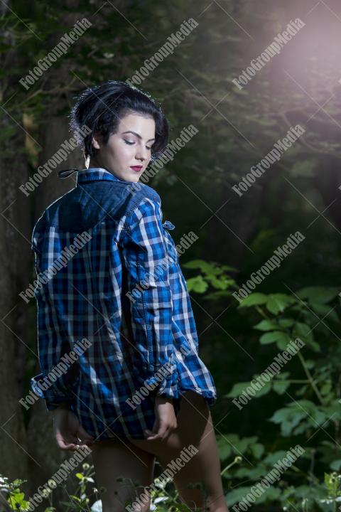 Pretty young girl in plaid shirt posing outdoor