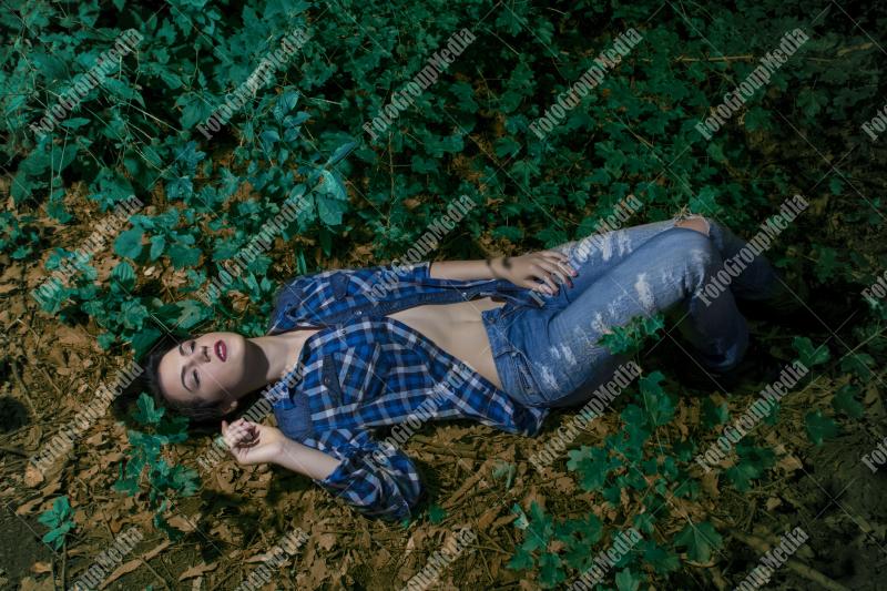 Yound woman dressed in plaid shirt and jeans posing outdoor