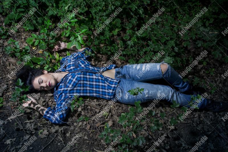 Yound woman dressed in plaid shirt and jeans posing outdoor