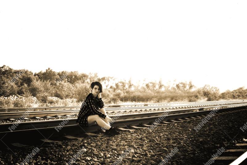 Young girl posing on railroad in a summer day