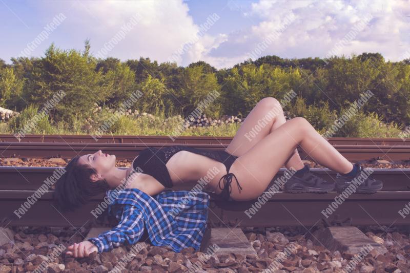 Young girl posing on railroad in a summer day