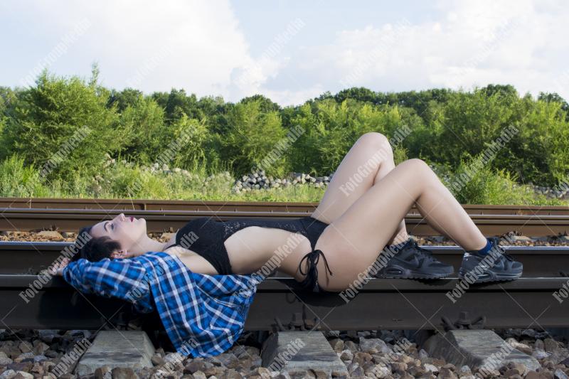 Young girl posing on railroad in a summer day