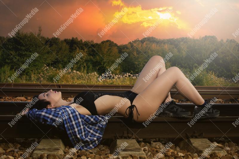 Young girl posing on railroad in a summer day