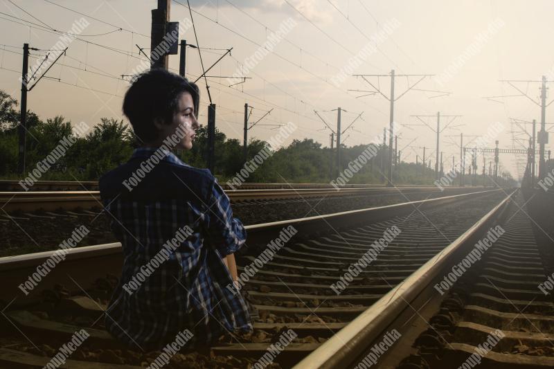 Young girl posing on railroad in a summer day