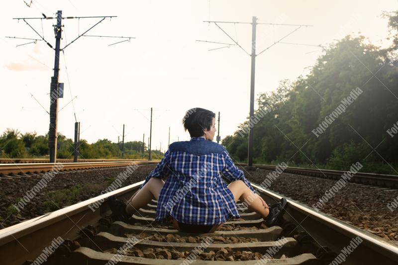 Young girl posing on railroad in a summer day