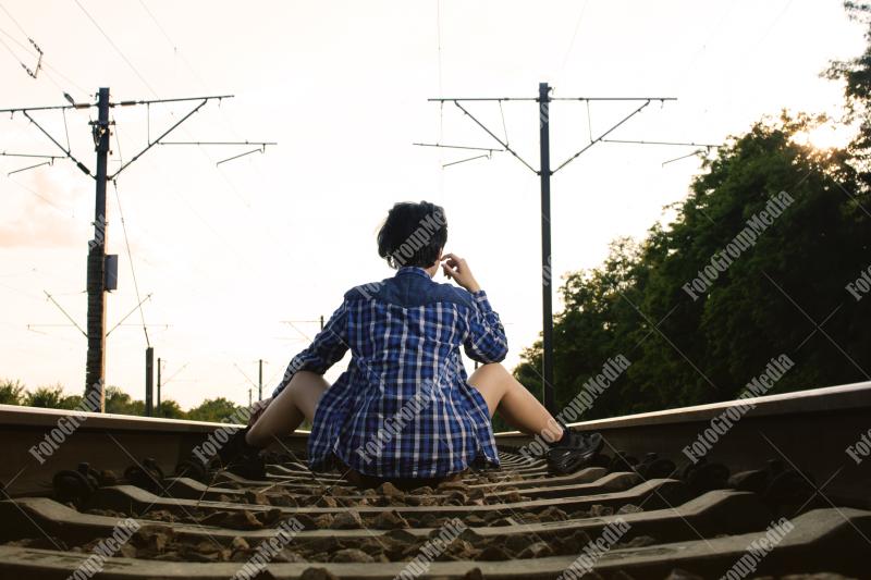 Young girl posing on railroad in a summer day