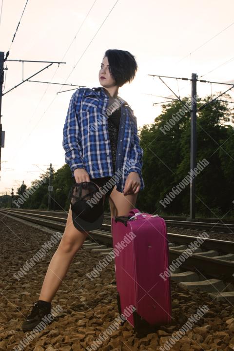 Young girl posing on railroad in a summer day
