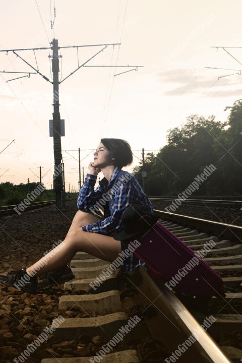 Young girl posing on railroad in a summer day