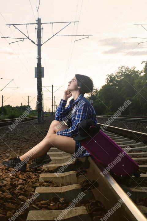 Young girl posing on railroad in a summer day