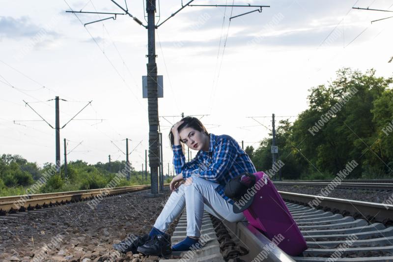 Young girl posing on railroad in a summer day