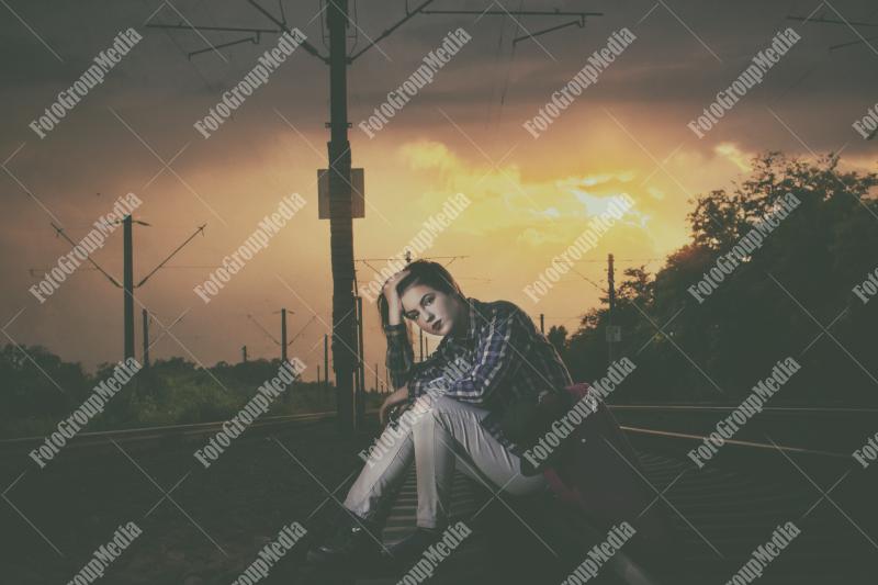 Young girl posing on railroad in a summer day