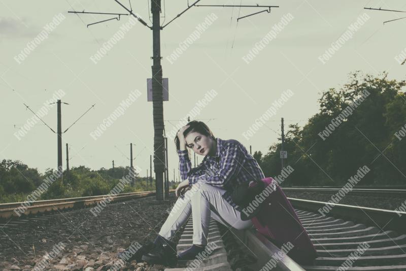 Young girl posing on railroad in a summer day
