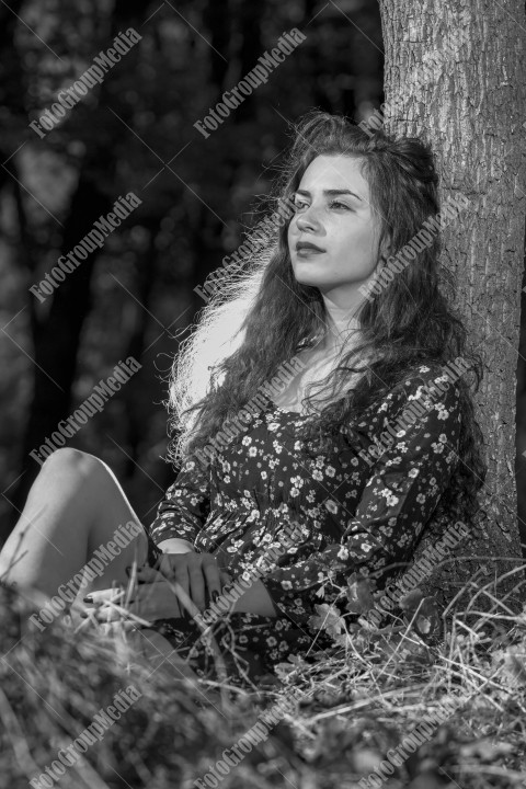 A fashionable and stylish woman poses gracefully while wearing a beautiful floral dress