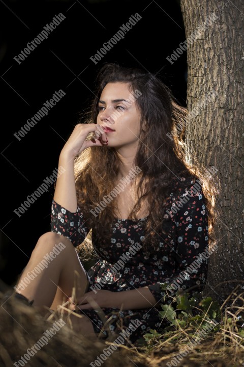 A fashionable and stylish woman poses gracefully while wearing a beautiful floral dress