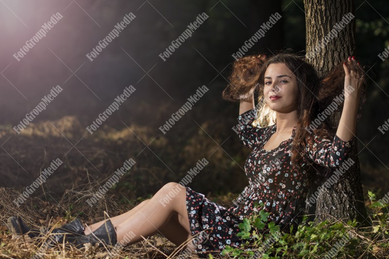 Beautiful young woman in floral dress enjoying a day in the park