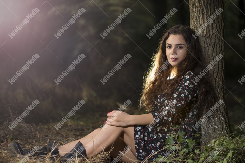 Beautiful young woman in floral dress enjoying a day in the park