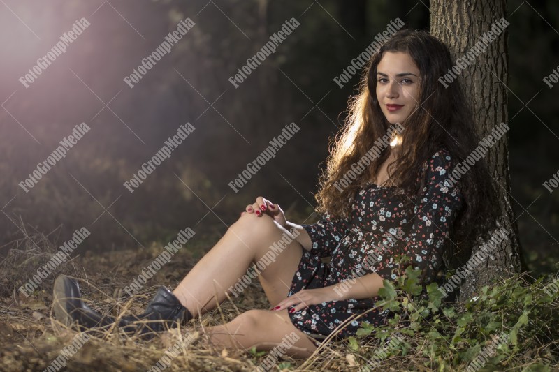 Beautiful young woman in floral dress enjoying a day in the park