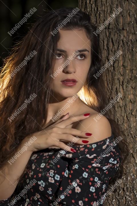 Beautiful young woman in floral dress enjoying a day in the park