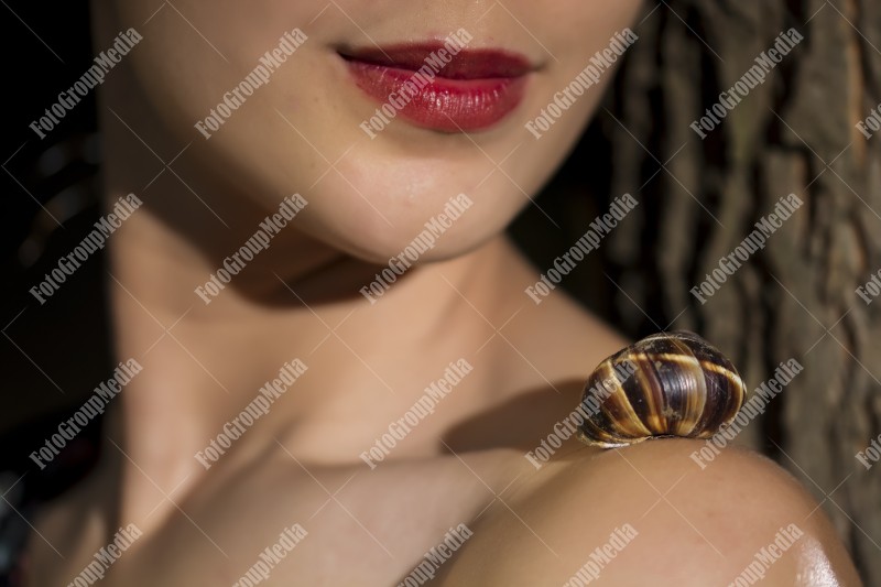 Close up of young girl face and snail on her shoulder
