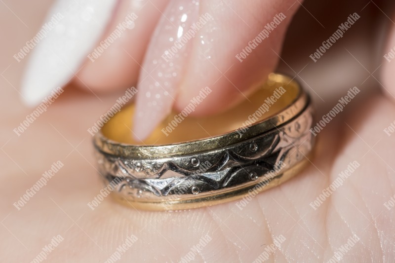 Close up of a woman hand holding a wedding ring