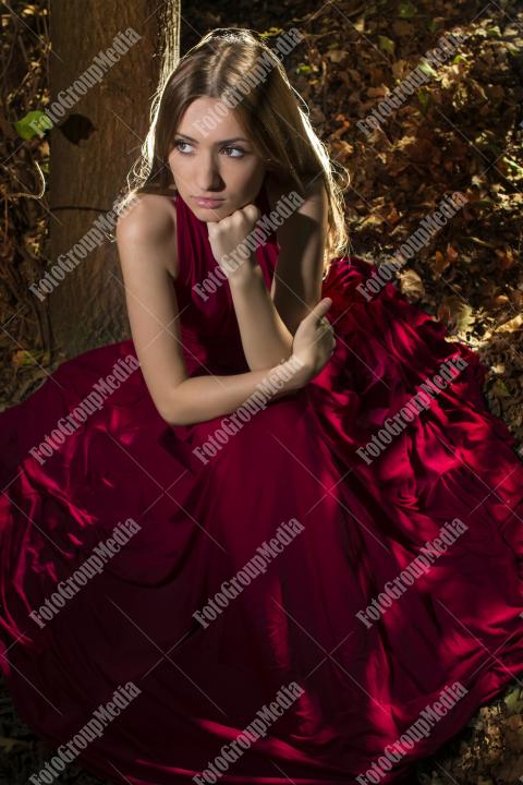 Red dress, a vibrant splash of color on a green forest background