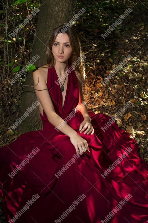 Red dress, a vibrant splash of color on a green forest background