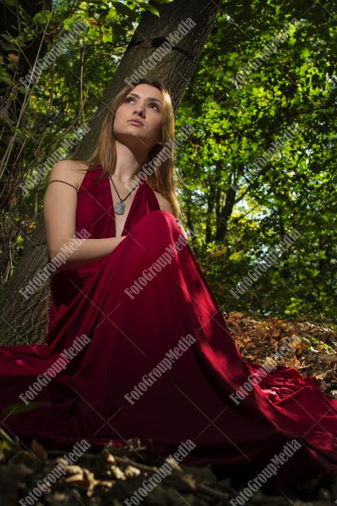 Red dress, a vibrant splash of color on a green forest background