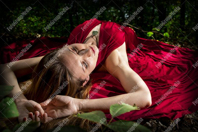Red dress, a vibrant splash of color on a green forest background