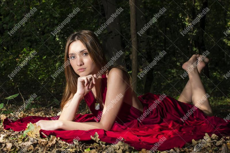 Red dress, a vibrant splash of color on a green forest background