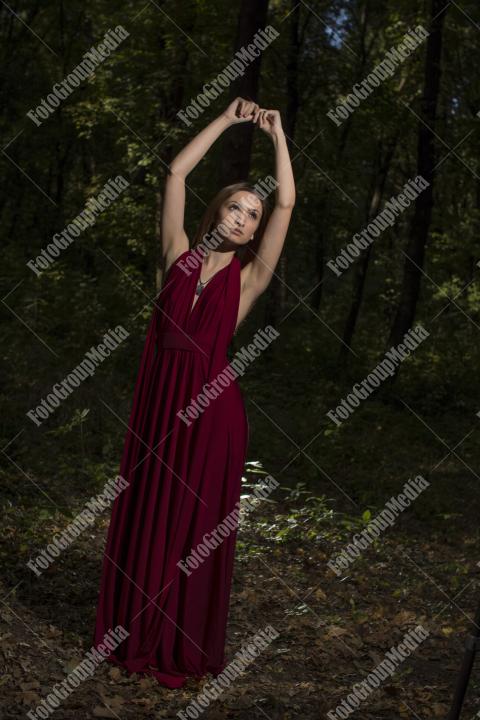 Red dress, a vibrant splash of color on a green forest background