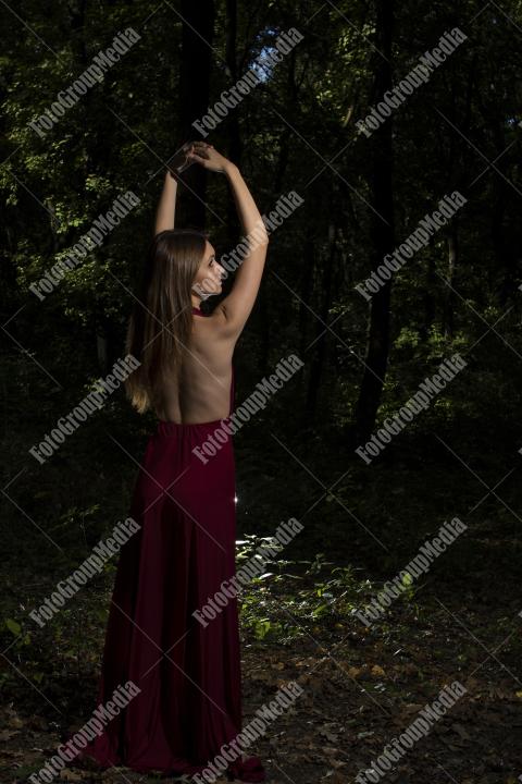 Red dress, a vibrant splash of color on a green forest background