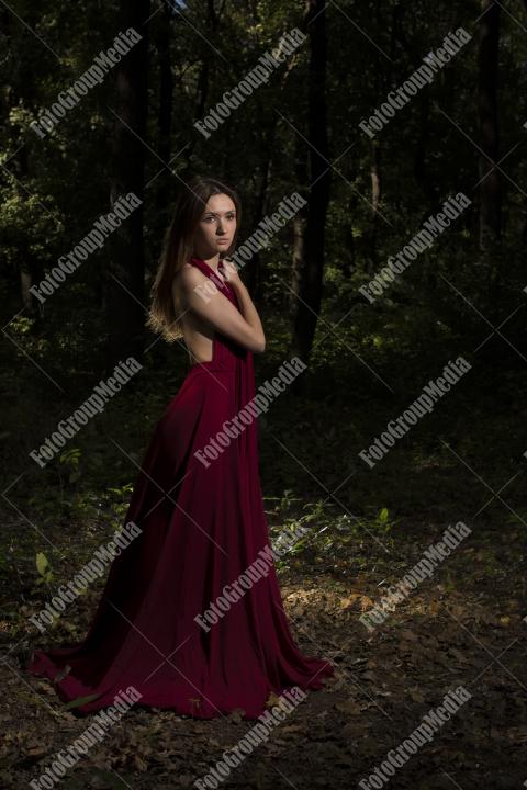 Red dress, a vibrant splash of color on a green forest background