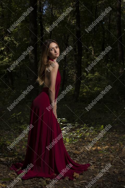 Red dress, a vibrant splash of color on a green forest background