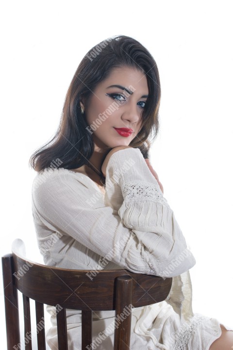 Fashion model posing in studio wearing white dress