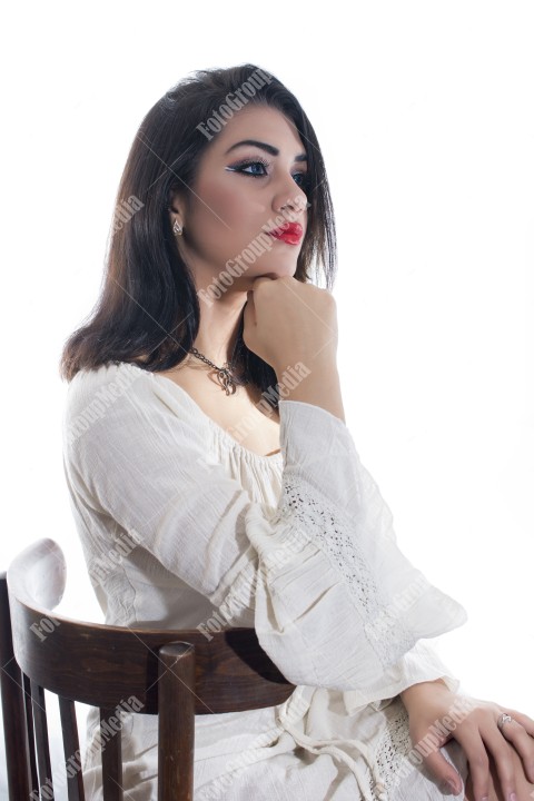 Fashion model posing in studio wearing white dress