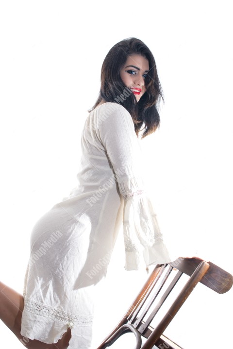 Fashion model posing in studio wearing white dress