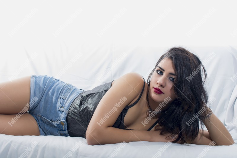 Brunette young girl posing on bed