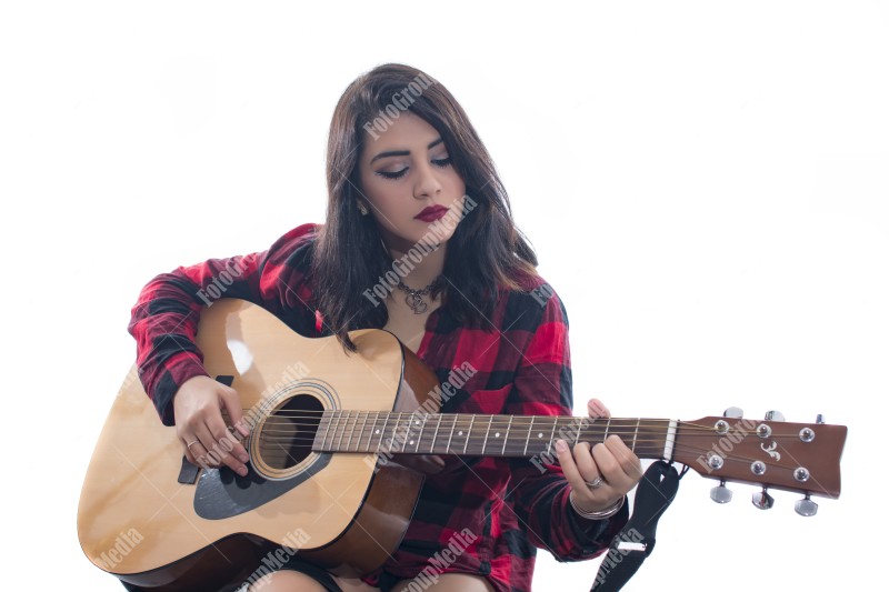 Playing guitar on bed in studio shoot