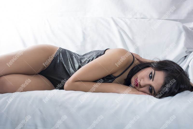 Brunette woman laying down on bed