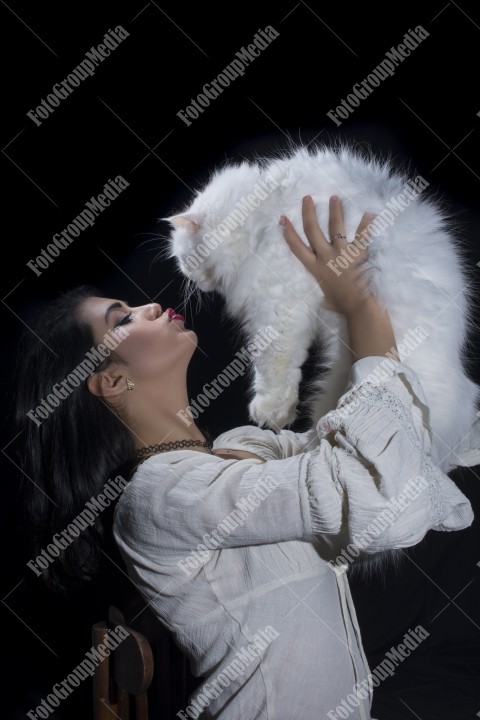 Portrait of young woman with cat on black background