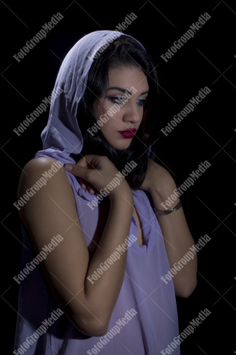 Fashion model posing in studio wearing purple dress